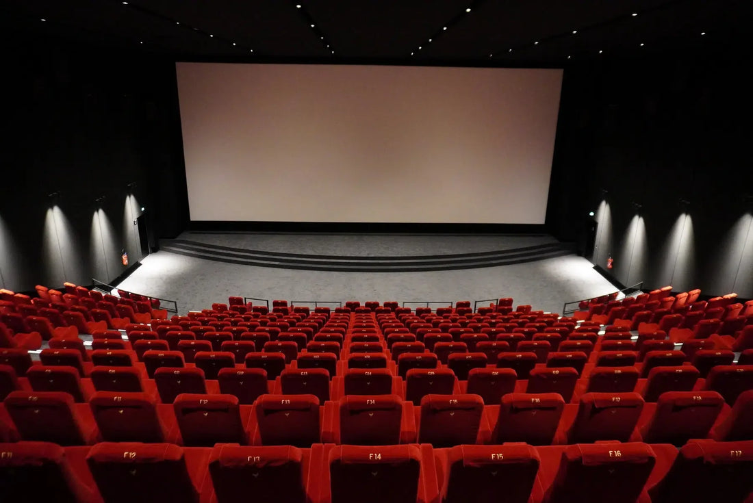 Échiquier dramatique éclairé comme sur un plateau de cinéma, avec caméra légèrement floue en arrière-plan et ambiance sombre et cinématographique.