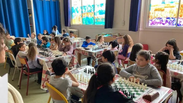 Une classe d’enfants ou d’adolescents jouant aux échecs sur plusieurs échiquiers, ambiance scolaire moderne et naturelle.