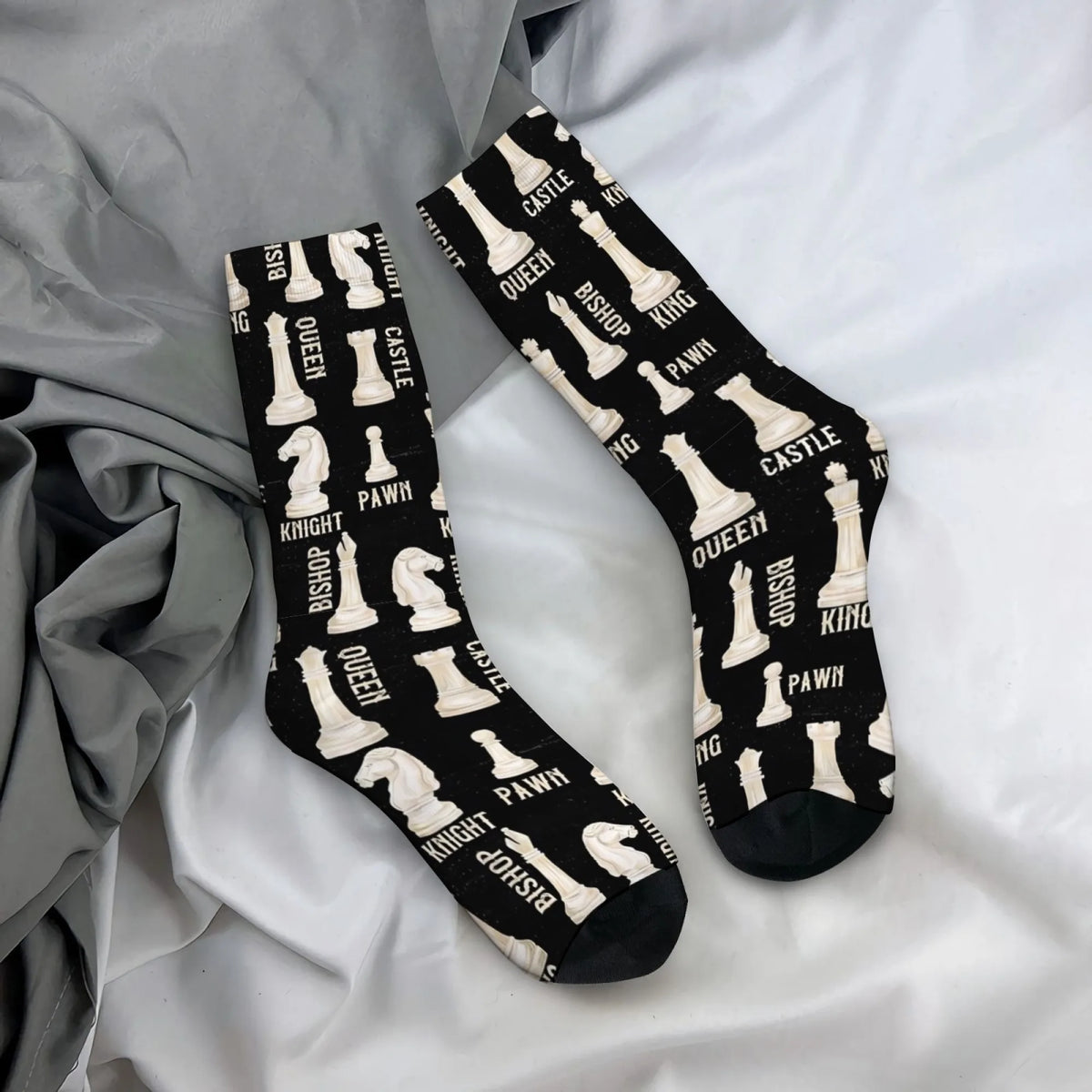 Chaussettes noires motif pièces échecs noms roi reine cavalier tour sur un drap blanc